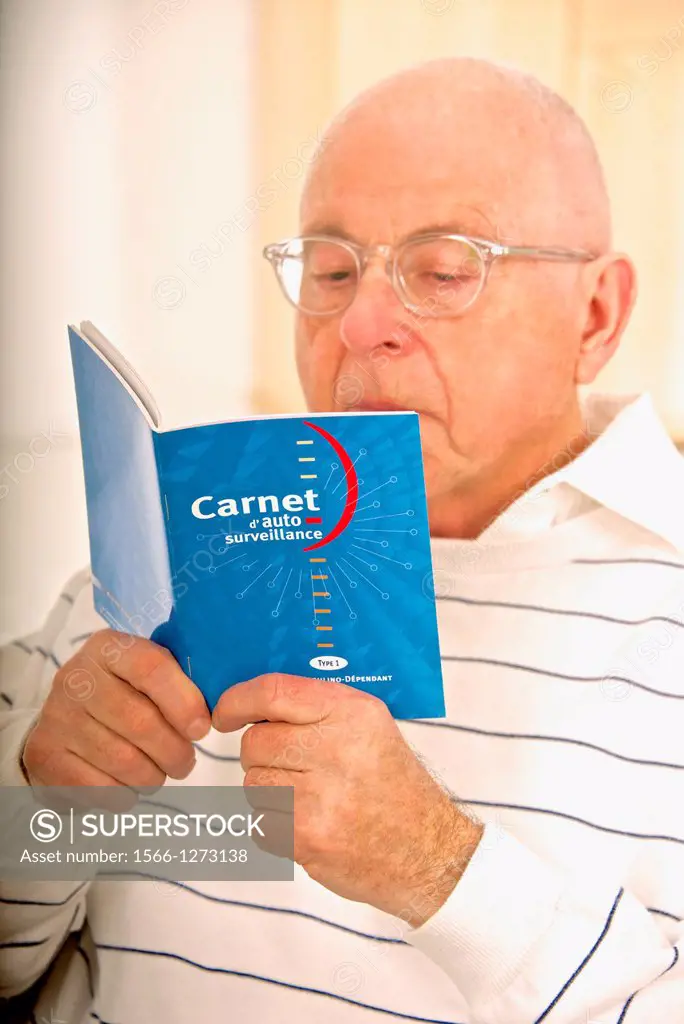 Senior man reading and controlling his diabetes results on his self testing blue booklet
