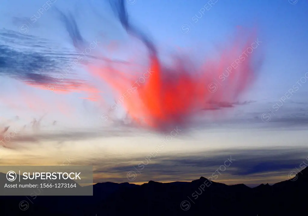 A setting sun provides color to wispy clouds along the Pacific Ocean in Baja California, Mexico