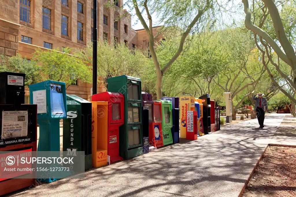 Newspaper boxes lined up on a sidewalk  Downtown Phoenix  Arizona  USA.
