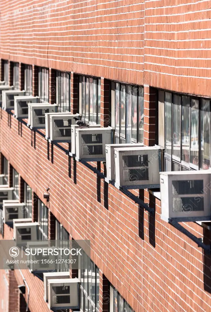 Multiple exterior air conditioning units at a house wall, climate change, PublicGround