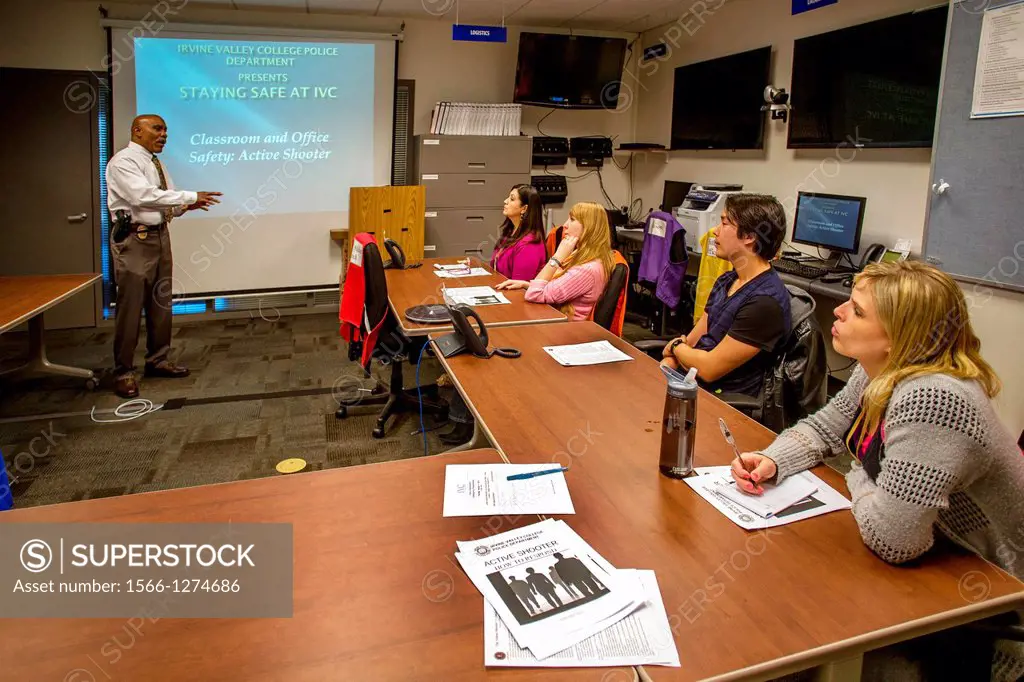 A college campus police chief in Irvine, CA, lectures administrators on safety procedures to prevent workplace violence. Note information on screen.A ...