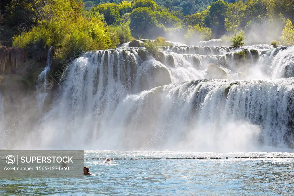 Croatia - Krka National Park, tourist taking bath near waterfall on the Krka River, Croatia.