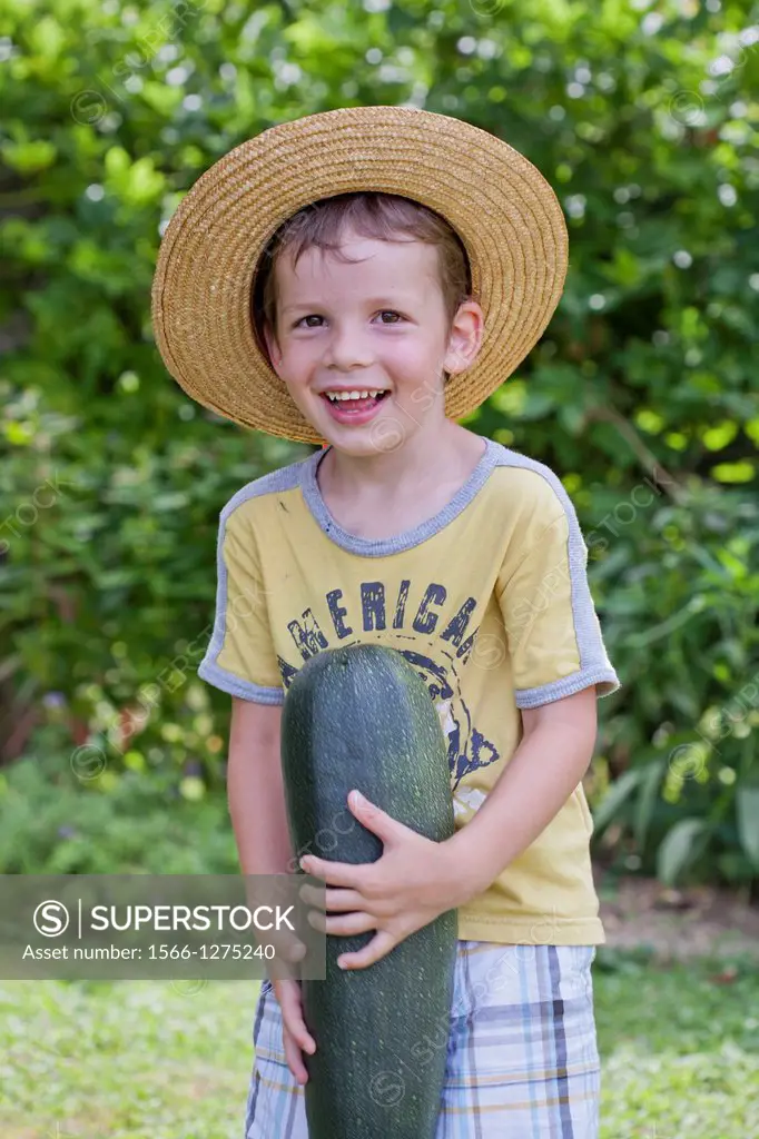 Young gardener with harvested vegetables.