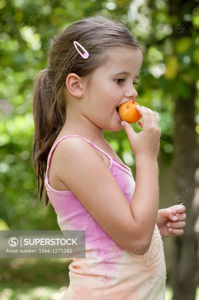 Girl eating apricot.