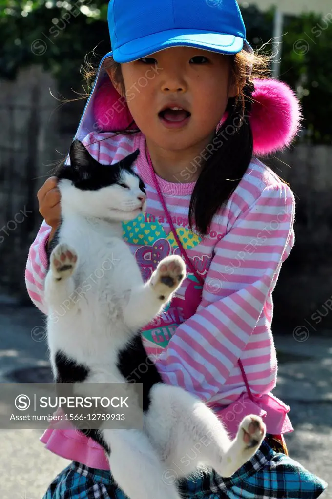 Naha, Okinawa, Japan: a young girl holding a cat