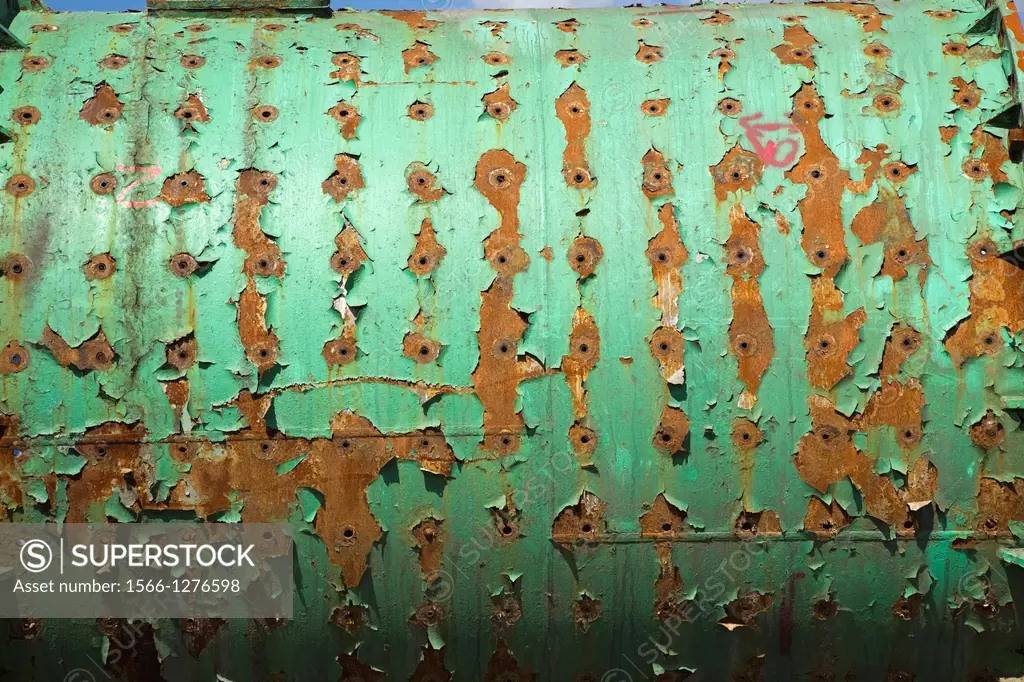 Close-up of an Industrial size Rusted Ferous Metal Cylindrical Chamber with Bored Holes and Peeling Green Paint in a Scrap Metal Recycling Junkyard, Q...