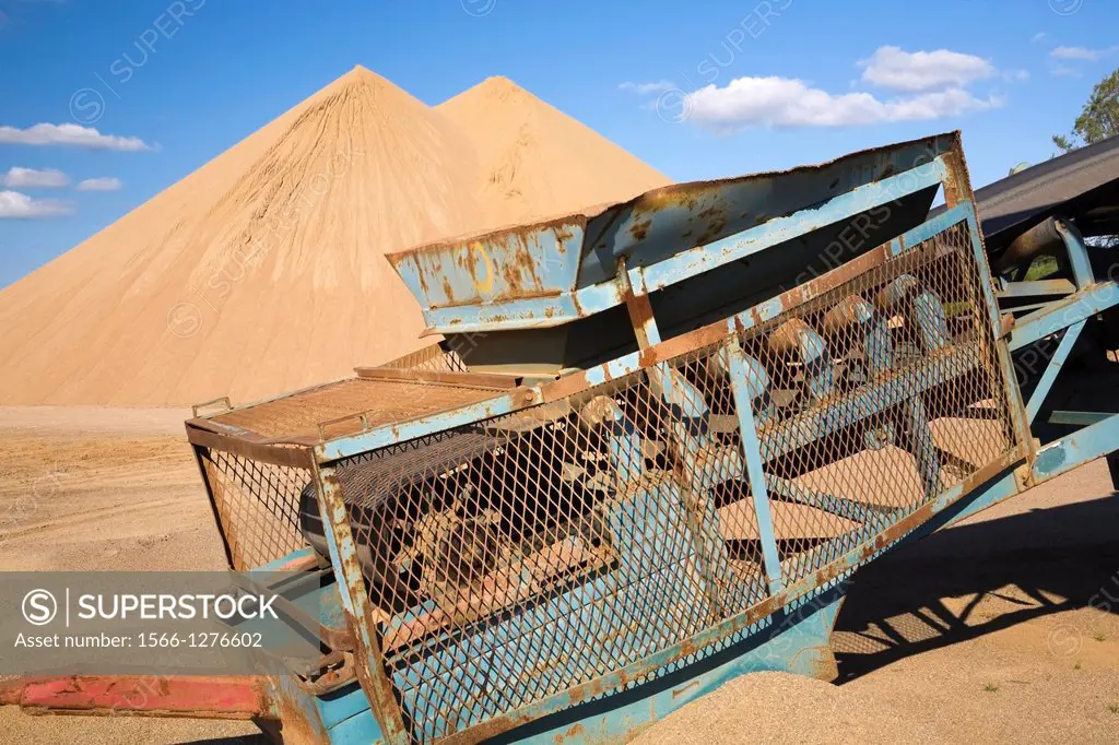 Old stacking conveyor and mounds of sand in a commercial sandpit, Quebec, Canada.