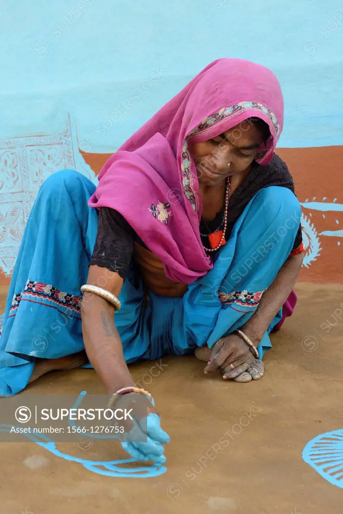 India, Rajasthan, Tonk region, Woman painting a geometrical floor mandana prior to Diwali festival.
