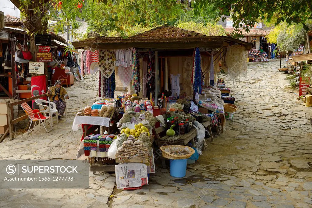 Woman knitting by street shops in hillside village of Sirince Turkey