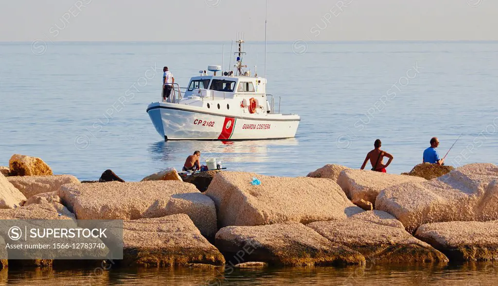 Boat of the Guardia Costiera, Italy´s coastguard, moored off the coast near fishermen, Molfetta, Puglia, Italy, Europe.