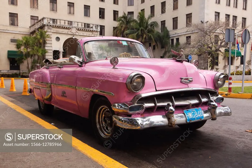 Pink coloured vintage American car in front of Hotel Nacional in Vedado district, Havana, Cuba, West Indies, Central America.