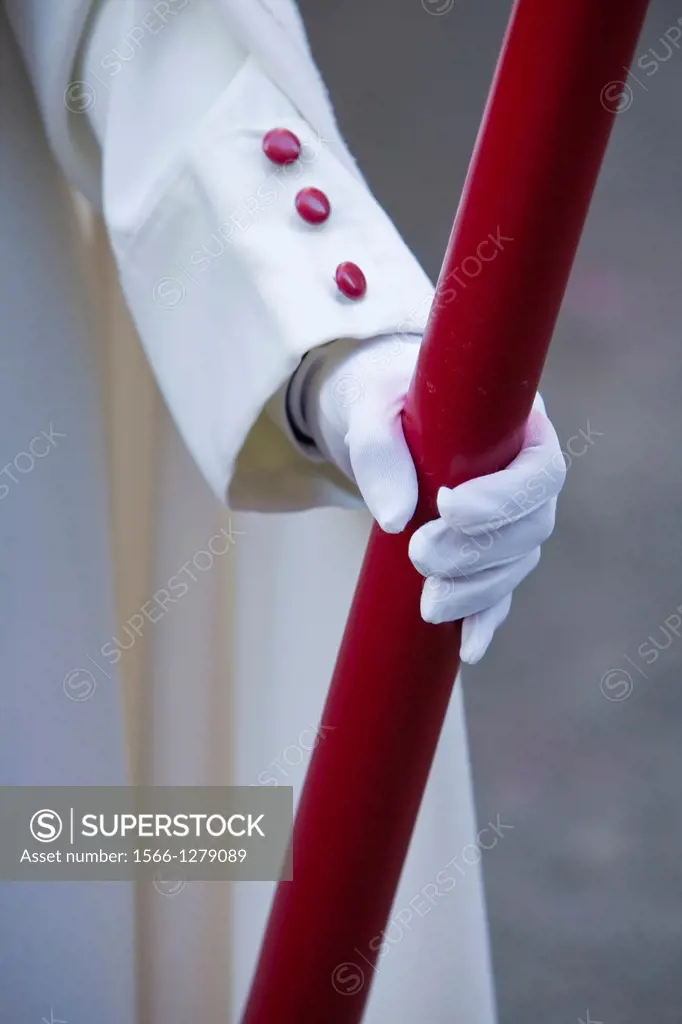 Detail penitent red holding a candle during Holy Week, Spain.