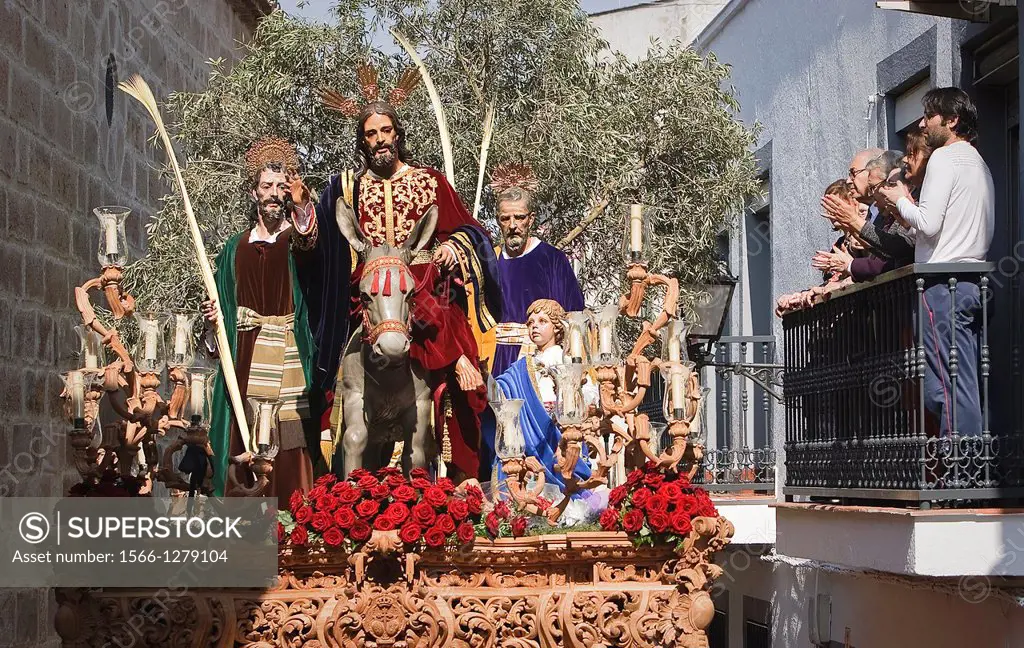 Family on a balcony watching the throne of the brotherhood of the entry in Jerusalem, Linares, JaŽn province, Spain.