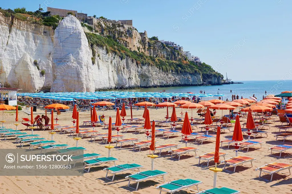 Pizzomunno a 25 metre high monolith and tourists and sun umbrellas on the beach at Vieste, Gargano promontory, Foggia province, Puglia, Italy, Europe.