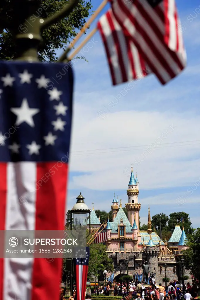 Sleeping Beauty Castle in Disneyland with US flags in foreground. Anaheim. California. USA.