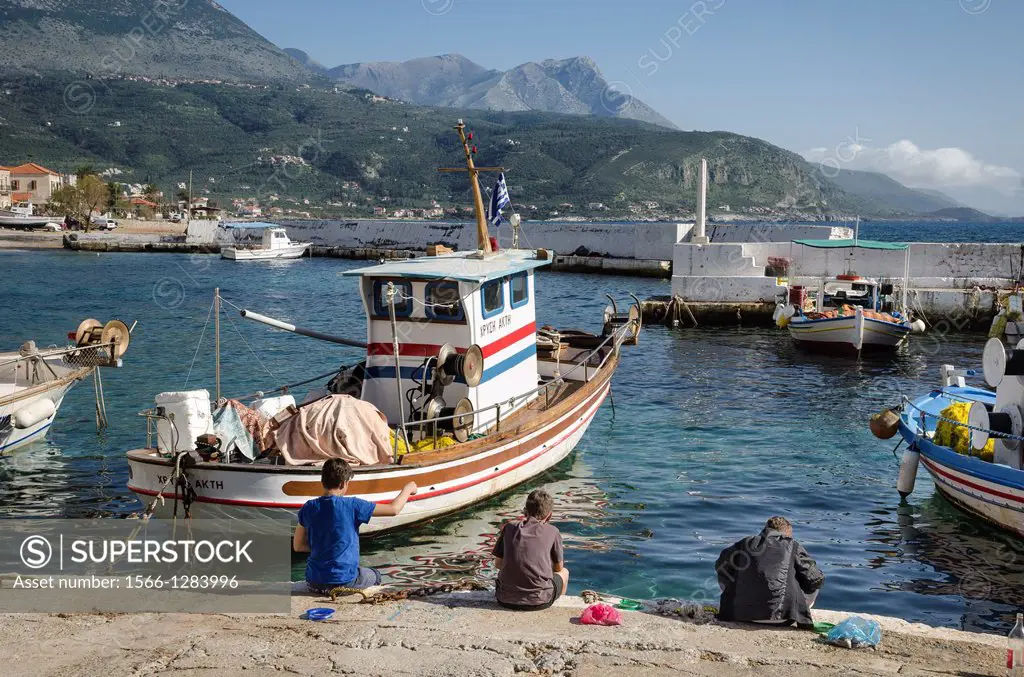 Children fishing in the harbour in the little fishing village of Ayios Nikolaos, in The Outer Mani, Southern Peloponnese, Greece.