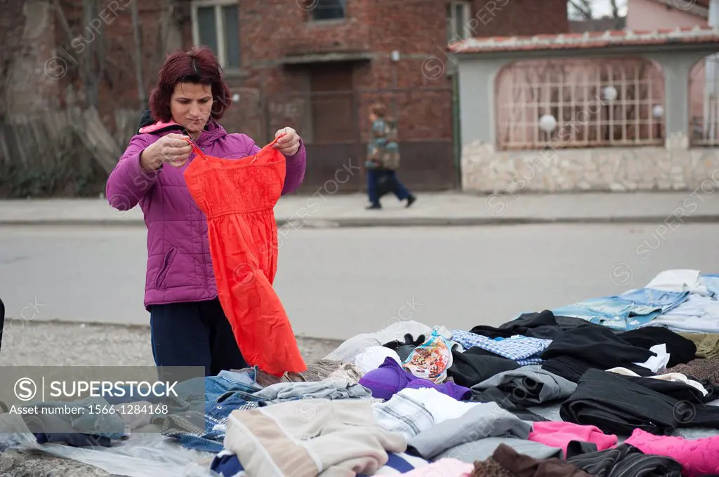 Sofia, Bulgaria. A Roma woman seeking a new red dress at a street side display