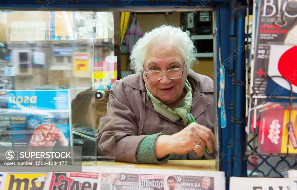 Sofia, Bulgaria. Older woman, working in a kiosk with magazines and newspapers.