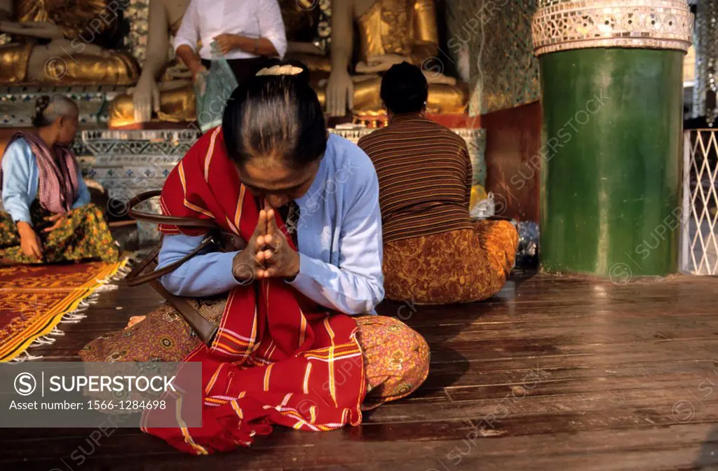 A Burmese woman praying very devoutly