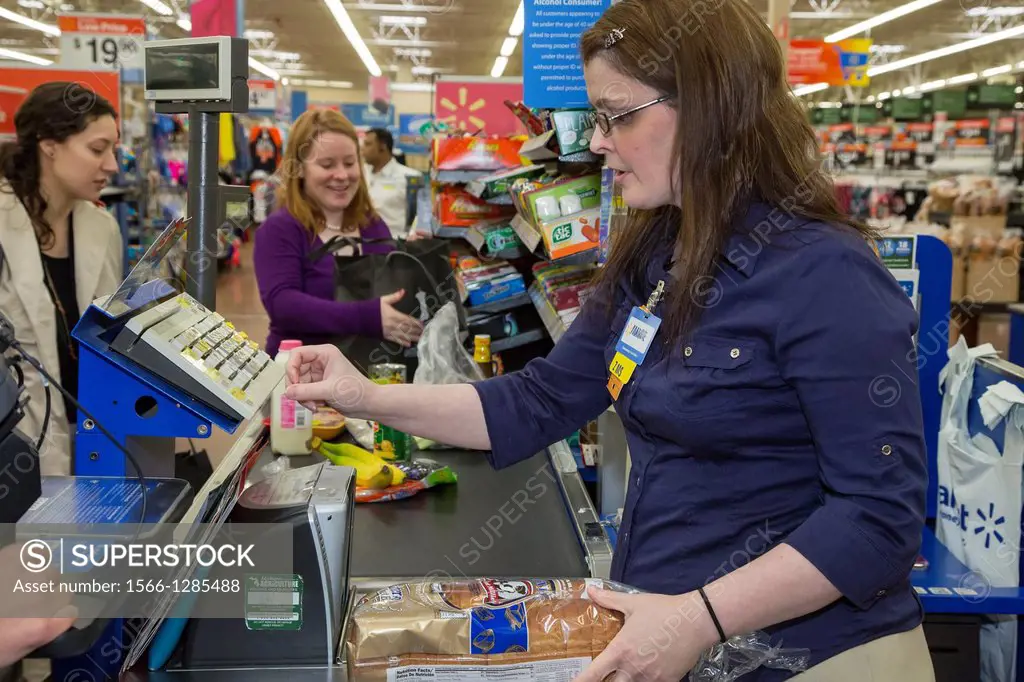 Sterling Heights, Michigan - A worker staffs a checkout lane at a Walmart store. She was checking out customers who participated in a ""Cooking Matter...