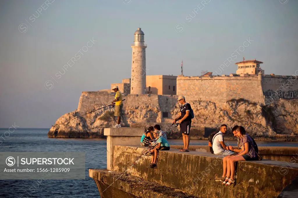 angler on malecon, lighthouse and fortress Castillo de los Tres Reyes del Morro or Morro Castle in Havana, Cuba, Caribbean.