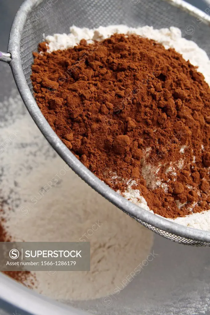 cocoa powder and plain flour in sieve over plastic mixing bowl.