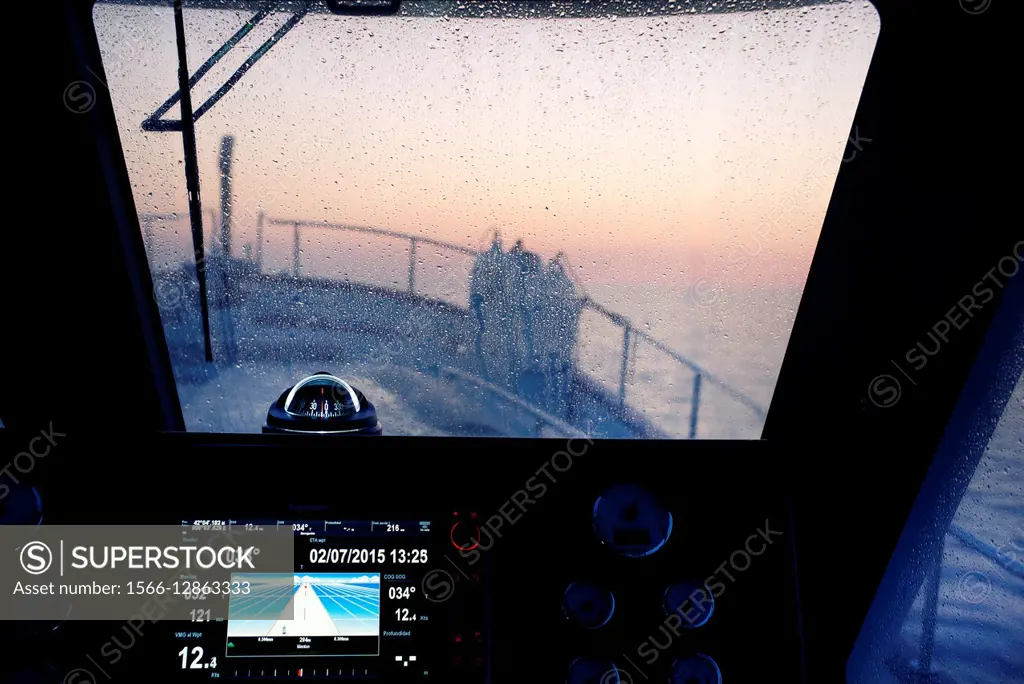 Wheelhouse of a fishing boat at dawn with autopilot and compass. Mediterranean Sea. Europe