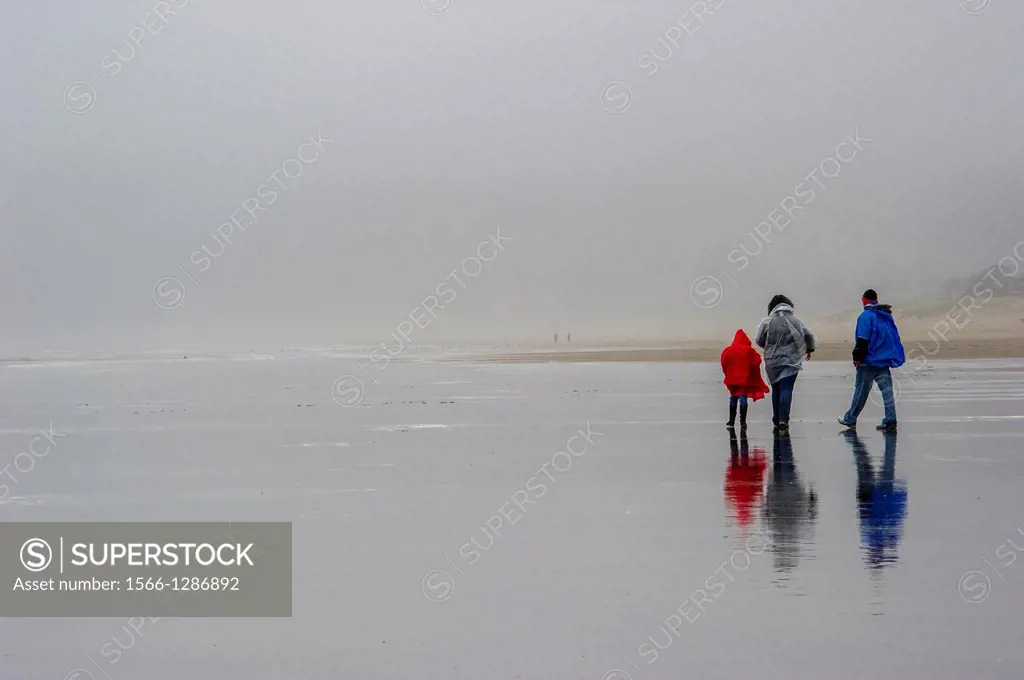 Family walking on rainy day on Cannon Beach.Cannon Beach,Oregon USA.