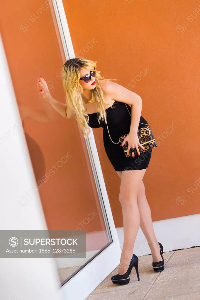 Fanciful young lady woman next to glass wall