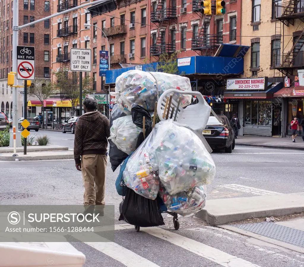 A deposit bottle collector in the bike lane in the Chelsea neighborhood of New York