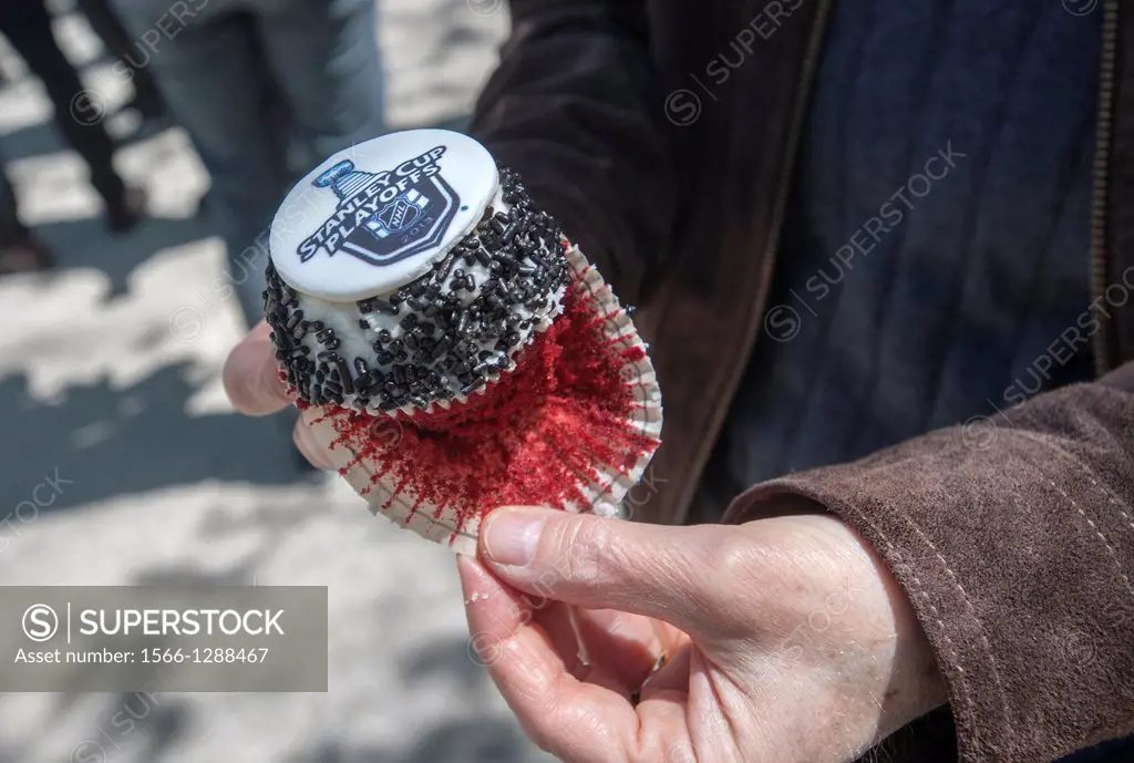 Happy hockey fans and other visitors get free promotional cupcakes in Madison Square Park in New York at the kick-off of the partnership between the N...