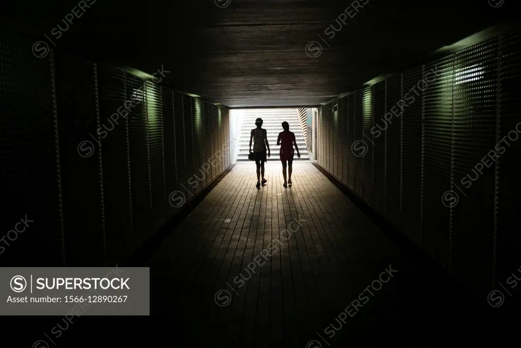 Silhouette of two people unrecognizable walking through a tunnel. Barcelona, Spain, Europe