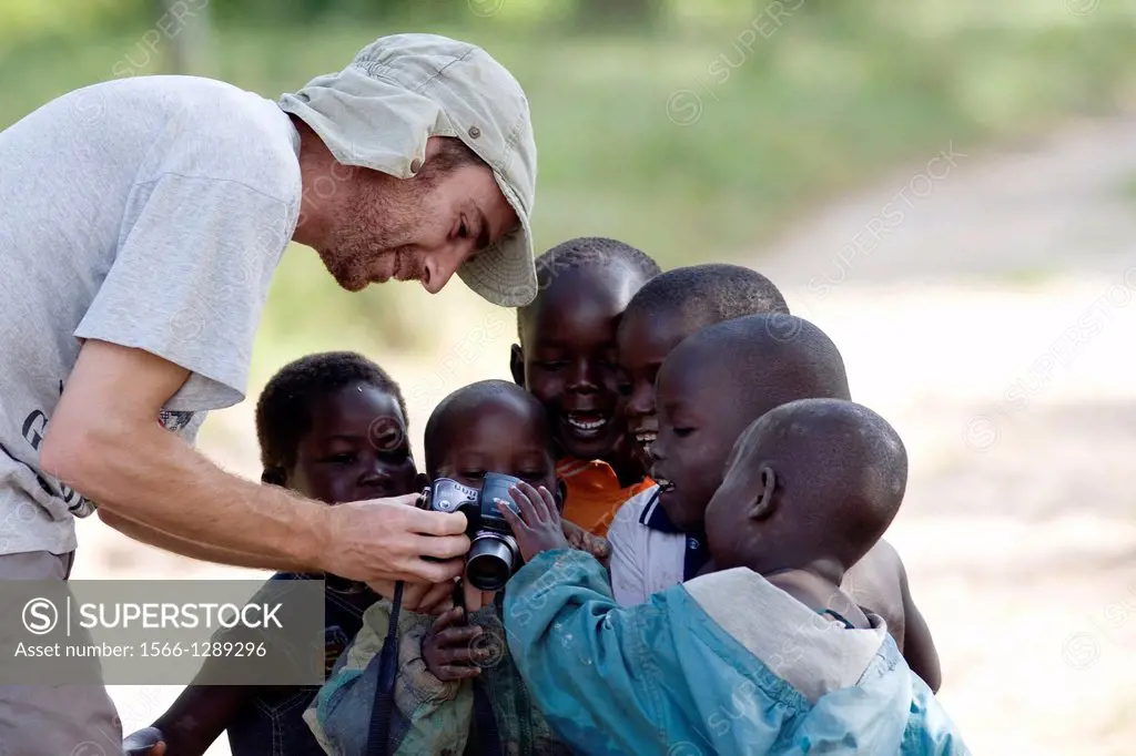 a tourist teaches children about a photo taken with digital camera, Ssese Islands, Lake Victoria, Uganda