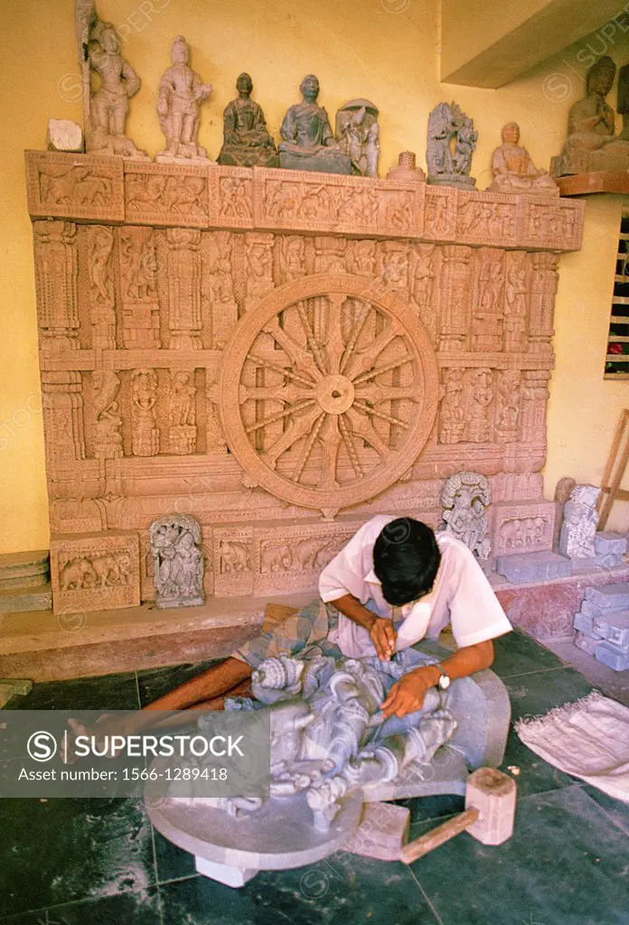 Man sculpting a statue of a hindu deity in a souvenir shop. Orissa state, India.