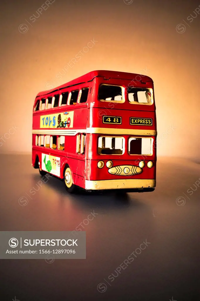 Concept, toy model replica of a red London double-decker bus, front view.
