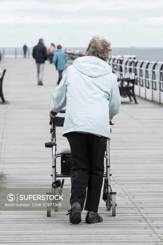 Elderly woman walking on Saltburn pier. Saltburn by the Sea, North Yorkshire, England, United Kingdom.