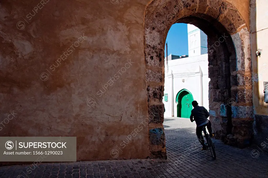 Boy riding a bicycle through the streets of Azemmour medina, Morocco.