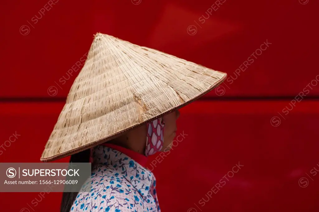 Vietnam, Hanoi, woman wearing traditional hat.