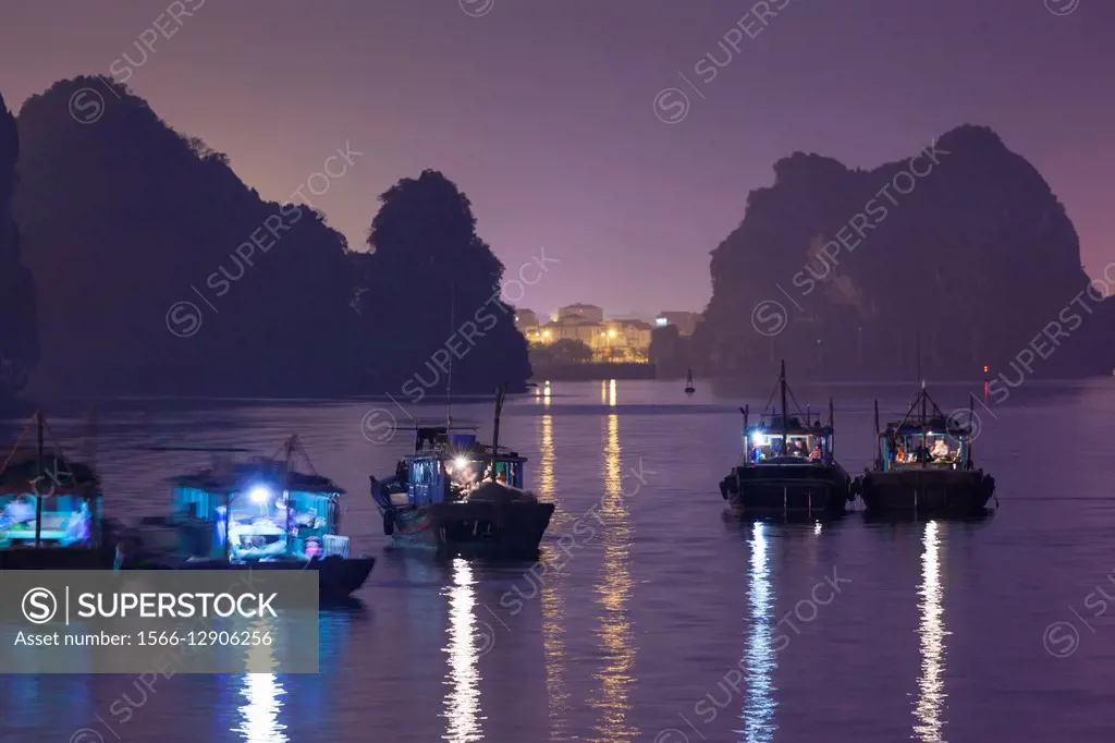 Vietnam, Halong City, Halong Bay fishing boats, dusk.