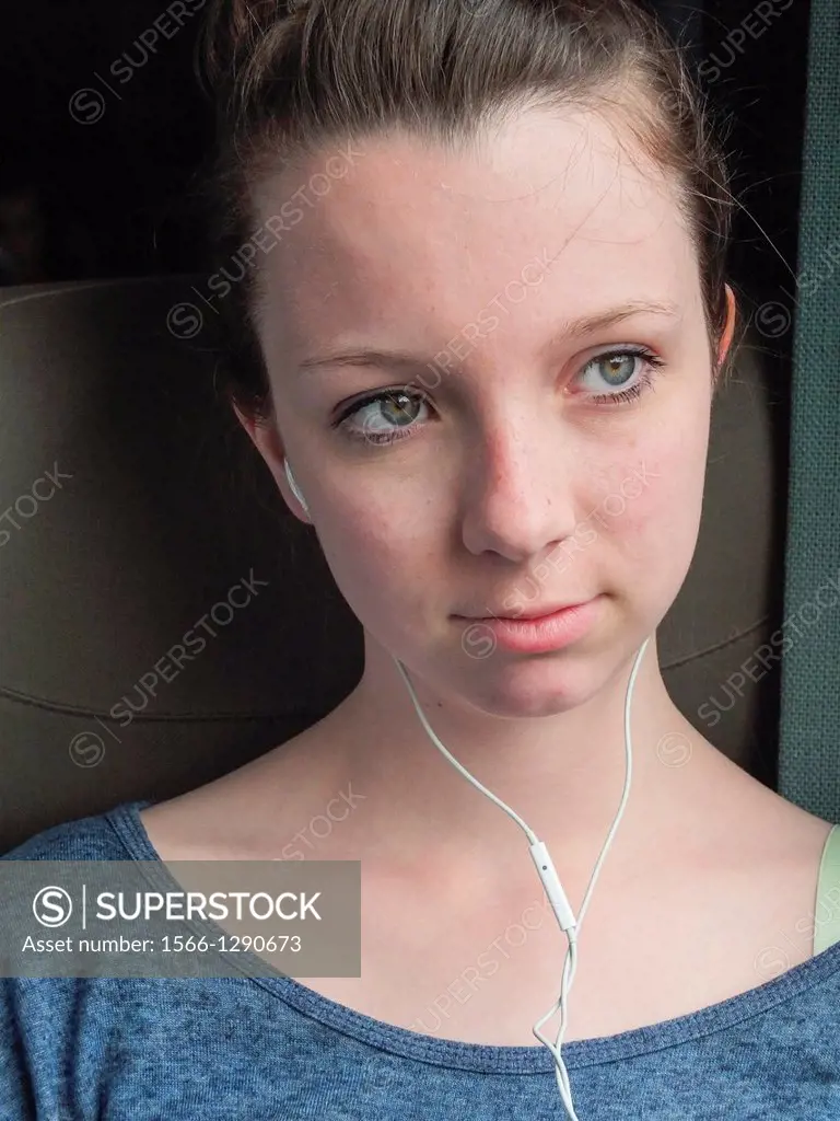 Teen ager in a train listening to music.