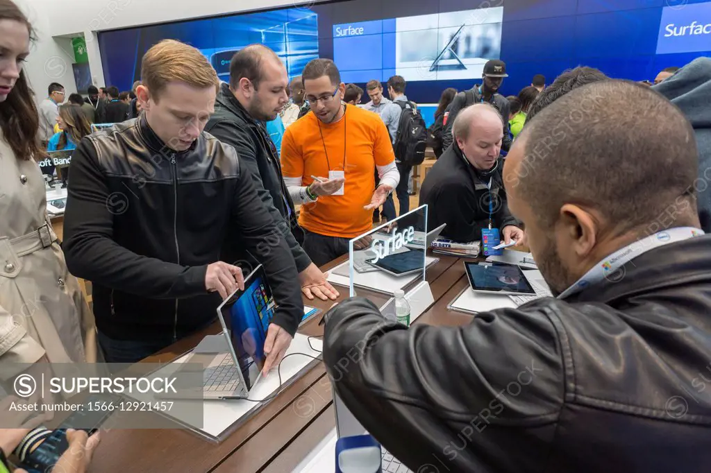 Shoppers try out Surface laptops at the Microsoft flagship store on Fifth Avenue in New York at its grand opening, Monday, October 26, 2015. Visitors ...