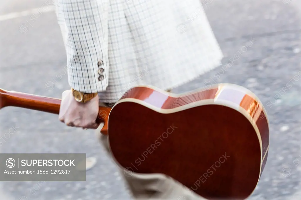 Musician carrying a spanish guitar on the street