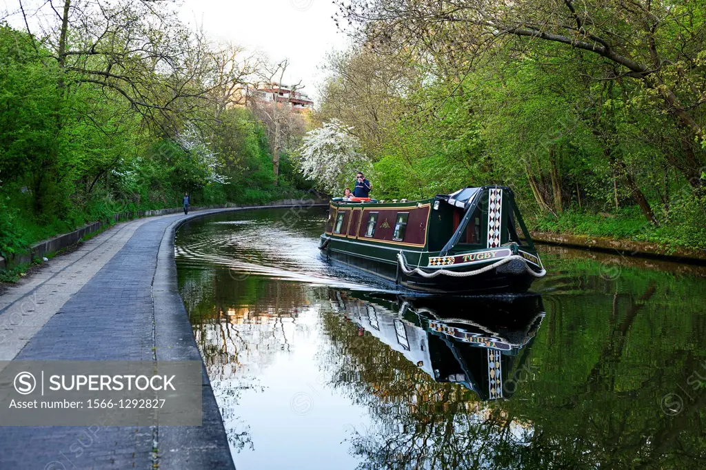 Boat navigating along Regents canal, near Regents Park, London, UK