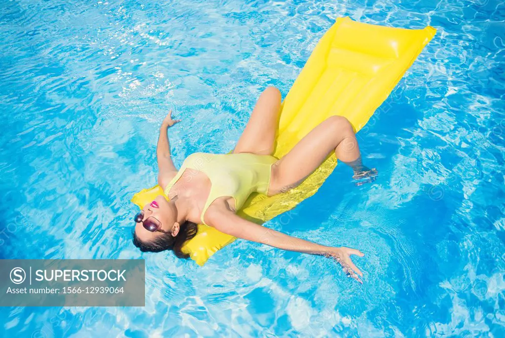 Woman on a air mattress in a swimming pool.