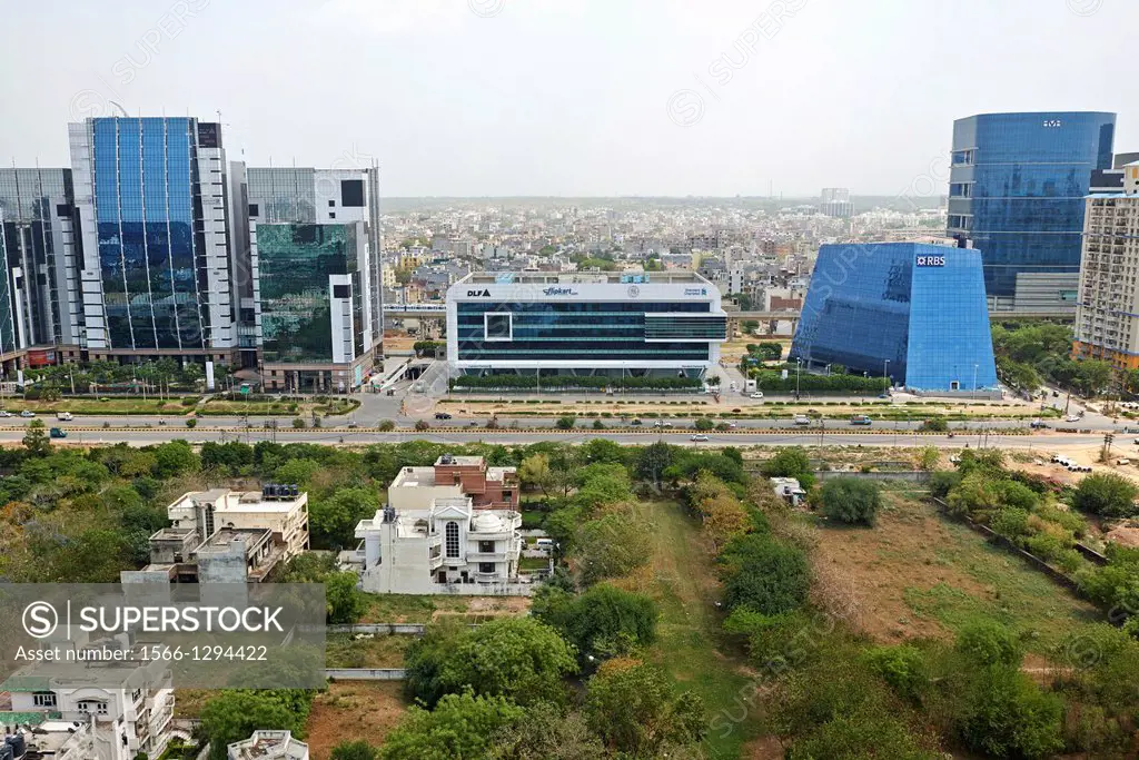 New tech buildings at a business park site opposite of old run down buildings in Delhi.