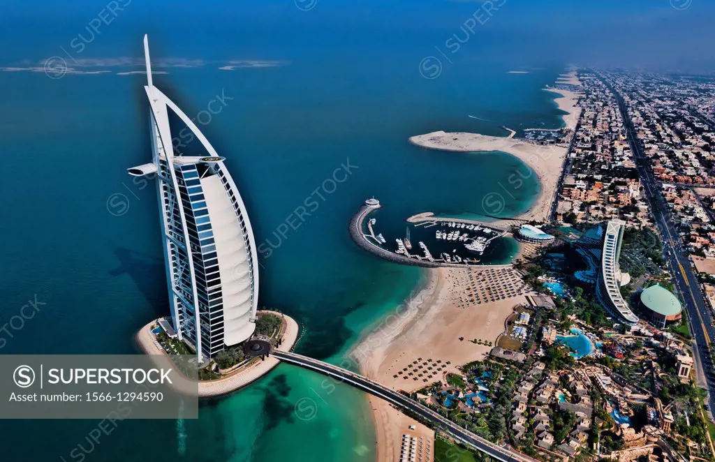 Worlds only 7 star hotel in Dubai UAE called the Burj Al Arab from helicopter above aerial with luxury and water at beach in United Arab Emirates.