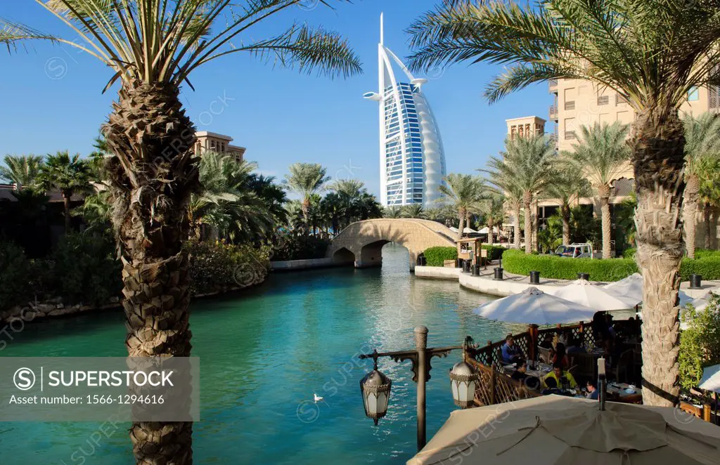 Wonderful 7 star Burj Al Arab hotel from the shopping mall at Madinat Jumeirah with boat and restaurants with palms in Dubai UAE inn thriving United A...