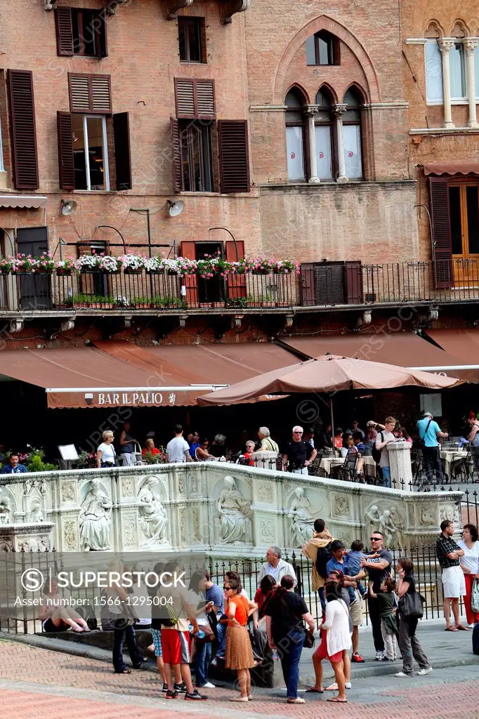 Tourists gathered around the Fonte Gaia in Piazza del Campo in Siena Italy.