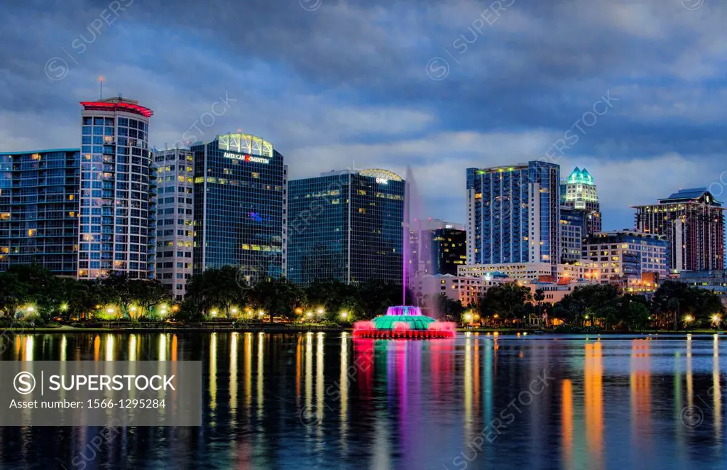 Orlando Florida Skyline and fountain at Lake Eola in early evening at sunset with reflections in the water.