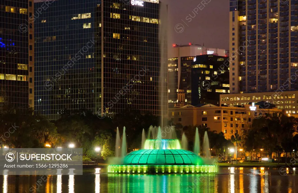 Orlando Florida Skyline and fountain at Lake Eola in early evening at sunset with reflections in the water.